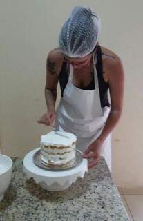 Aline trabalhando na produção de bolo; ela divide a semana entre aulas e doces (Foto: Arquivo pessoal)