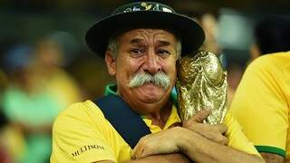 O &quot;Gaúcha da Copa&quot;, Clóvis Acosta Fernandes, chorando abraçado à taça Fifa, na derrota de 7 a 1 do Brasil diante da Alemanha na Copa de 2014 (Foto: (Ivan Pacheco/VEJA)