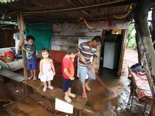 Rodrigo Soares limpa barraco depois da chuva, sob olhar dos filhos (Foto: Saul Schramm)