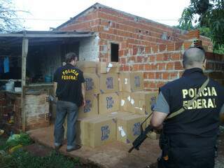 Policiais federais chegam em depósito de cigarro contrabandeado em bairro de Dourados. (foto: Divulgação/PF)