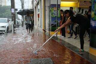 Funcionários param atendimento para tirar água das lojas (Foto: Marcos Ermínio)