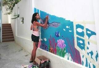 Lyara pintando em um hostel em Santa Marianita, no Equador