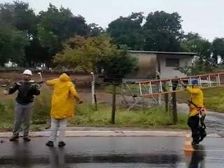 Equipes trabalham em meio à chuva em local onde veículo derrubou poste
