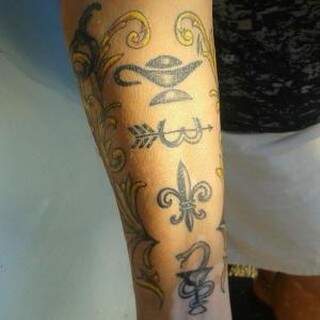 Márcia tatuou no braço, os símbolos das profissões de 3 dos seus filhos. (Foto: Arquivo Pessoal/Alinne Tatoo Studio) 