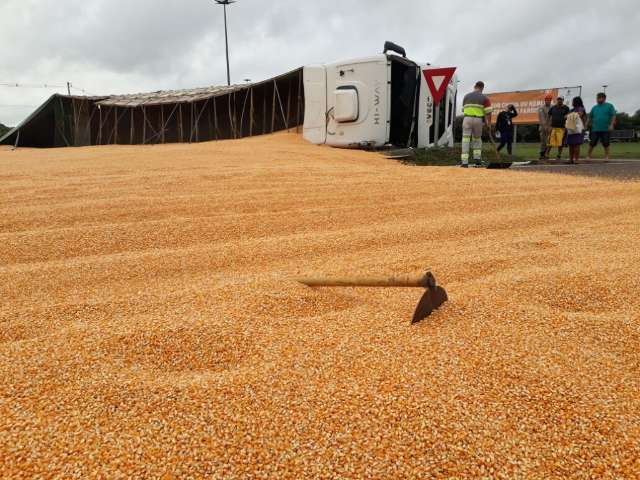 Carreta carregada de milho tomba e carga se espalha na pista 