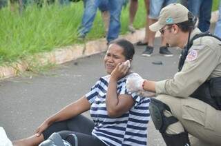 Bombeiro acompanhar mulher de vítima de acidente (Foto: Marcelo Calazans)