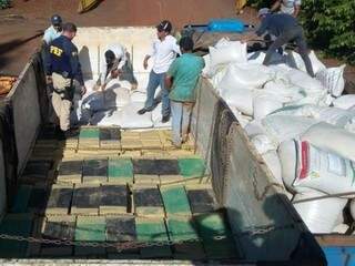 Sacos de farelo foram retirados do caminhão e drogas estavam embaixo (Foto: Divulgação PRF)