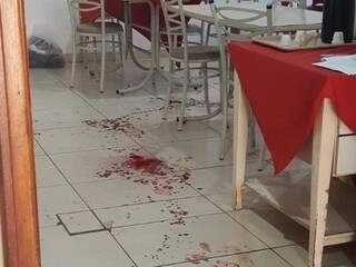 Marcas de sangue ficaram pelo chão de restaurante, após dono ser atingido por quatro tiros (Foto: Fábio Campos/Rádio Caçula)