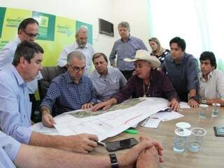 Reinaldo Azambuja (ao centro) observa projeto apresentado durante Governo Presente (Foto: Divulgação)