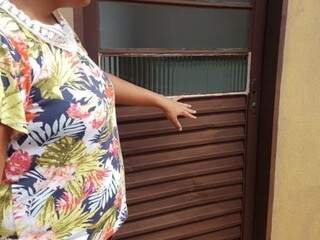 Moradora que teve casa invadida mostra porta que foi arrombada. (Foto: Anahi Gurgel). 