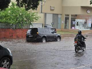 Volume da chuva faz água ultrapassar nível de calçada no Centro de Campo Grande. (Foto: Marlon Ganassin)