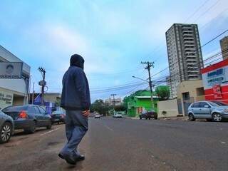 Agasalhado, homem atravessa a rua; casacos serão úteis até domingo (Foto: André Bittar)