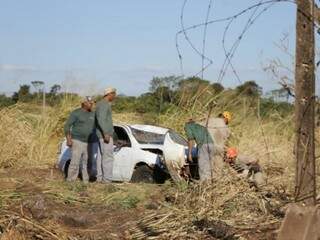 Carro danificado após capotagem; funcionários de empresa que ajudaram motoristas e militares do Corpo de Bombeiros (Foto: Kisie Ainoã)  