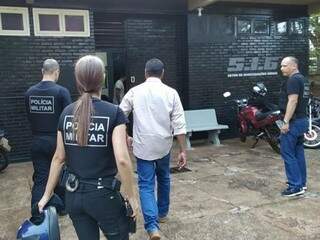 Policial militar (de camisa clara) é conduzido por PMs da Corregedoria após ser preso hoje em Dourados (Foto: Adilson Domingos)