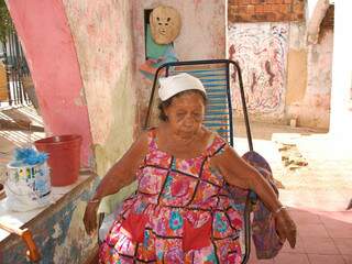 Sentada em uma cadeira de fio na varanda da casa, Dona Maria parece não se incomodar com os &#039;inquilinos&#039;. (Fotos: Simão Nogueira)
