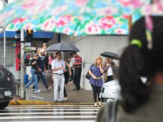 De cores e flores apenas o guarda-chuva da pedestre traz a estampa da primavera. (Foto: João Garrigó)