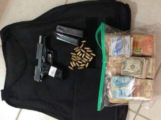 Colete, armas, munições e dinheiro apreendidos durante operação. (Foto: Divulgação/ PF)