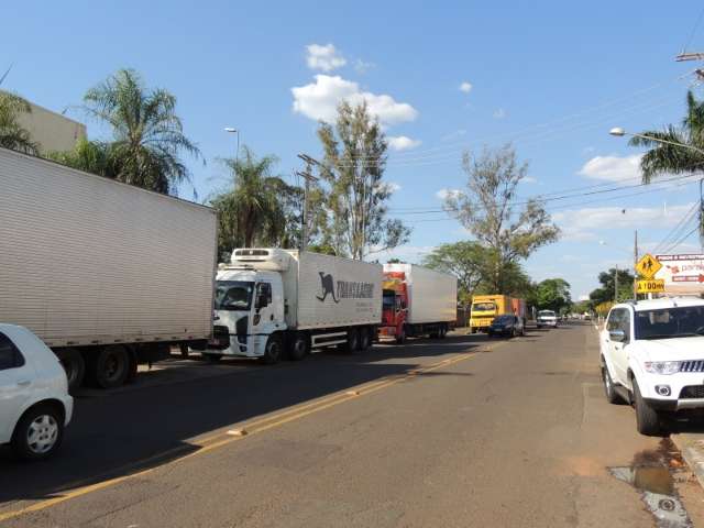 Enquanto aguardam descarga, caminh&otilde;es obstruem avenida na Vila Rica