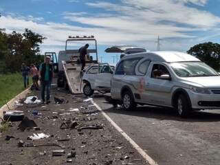 Carro da funerária retira os corpos do local do acidente. (Foto: Miriam Machado)