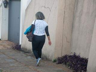 Com casaco na mão, mulher caminho em vias do Bairro Jardim dos Estados, nesta tarde (05). (Foto: Paulo Francis)