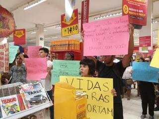 Manifestantes segurando cartazes com frases de conscientização (Foto: Direto das Ruas) 