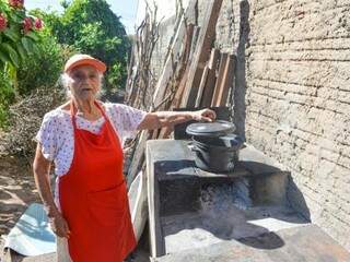 No fogão a lenha no quintal de sua casa, ela faz comida, doces e sabão para vender (Foto: Simão Nogueira)