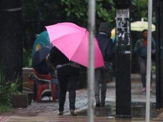 Campo-grandense com guarda-chuvas na manhã desta quarta na Praça Ary Coelho (Foto: Saul Schramm)