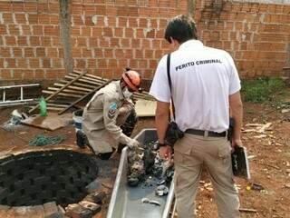 Bombeiro e perito da Polícia Civil examinam ossos humanos encontrados em poço, no distrito de Panambi (Foto: Adilson Domingos)