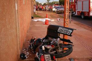 Motocicleta parou entre muro e ponto de ônibus e corpo de rapaz aproximadamente 5m depois. (Foto: Mariana Lopes)