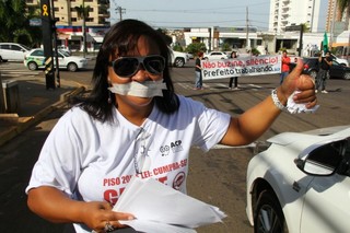Com esparadrapos na boca e faixa pedindo silêncio, professores iniciam a semana com protesto irreverente em frente à Prefeitura (Foto: Marcos Ermínio)