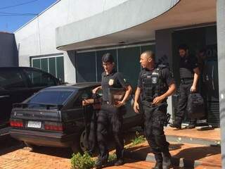 Policiais saindo com malote do Instituto Ícone. (Foto: Bruna Kaspary)