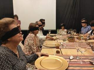 Os convidados da &quot;Vivência Sensorial Gastronômica às Cegas&quot; na mesa esperando pelos pratos (Foto: Divulgação)