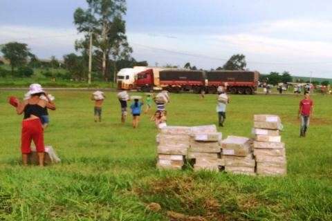 Carreta carregada de frango tomba e moradores saqueiam carga; veja v&iacute;deo