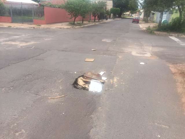 Vizinhan&ccedil;a improvisa e tapa com entulho buraco que cresce a cada chuva