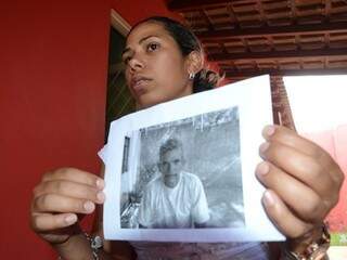 Maria Inês mostra a foto do pai, que está desaparecido desde domingo (Foto: Minamar Júnior)