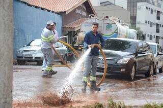 Funcionários limpavam rua Alan Kardec no Amambai depois de 10 dias de reclamações. (Foto: Minamar Junior)