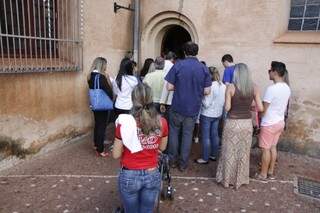 Em uma das portas laterais da igreja, devotos não conseguem nem entrar.