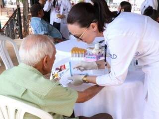 Profissional da saúde passando orientações sobre doenças renais a idoso (Foto: Henrique Kawaminami)