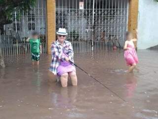 Mulher aproveita para pescar ao lado de crianças (Foto: Diário Corumbaense)