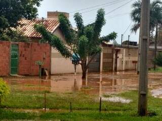 Água chegou próximo aos portões das casas no Nova Campo Grande (Foto: Ayanna Talebi)
