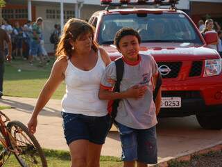 Aluno sai passando mal, acompanhado da mãe, na tarde de ontem, de escola no Rita Vieira. (Foto: Simão Nogueira)