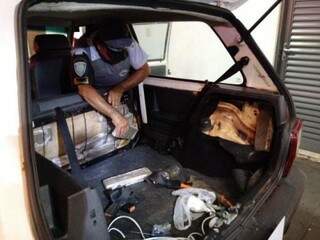 Policial retira tabletes de maconha de Fiat Uno apreendido no interior paulista (Foto: Divulgação)