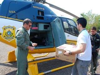 Servidor do TRE coloca urna substituta, que será levada para Anastácio, em helicóptero da PRF. (Foto: Simão Nogueira)