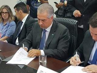 Governador do Estado, Reinaldo Azambuja (PSDB),
assinando convênio no TJMS. (Foto: Miriam Machado/Arquivo).