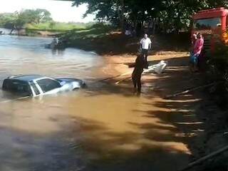 Com cabo de aço, carro é retirado de rio após afundar em correnteza