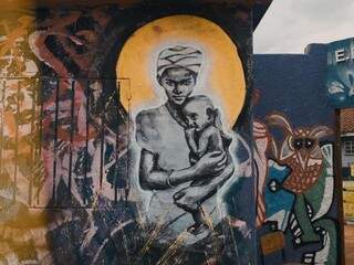 Colagem da mãe segurando o filho estampada no muro da escola (Foto: Leonardo Mareco)