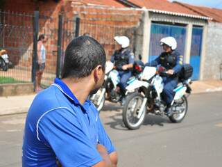 Mecânico observando policiais militares durante patrulhamento de rua (Foto: João Garrigó)