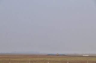 Céu cinza e pista do Aeroporto Internacional de Campo Grande vazia nesta manhã; visibilidade está comprometida por causa de cortina de fumaçam (Foto: Henrique Kawaminami)
