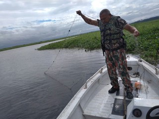 Policial ambiental durante apreensão de rede de pesca (Foto: Divulgação/ PMA)