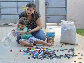 Juliana e o filho Pietro cuidam das tampinhas (Foto: Alana Portela)